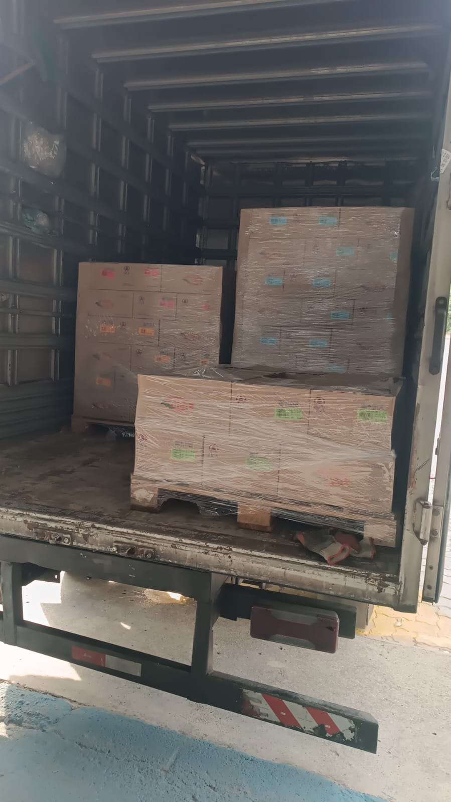 Caminhão baú carregado com paletes de caixas embaladas
